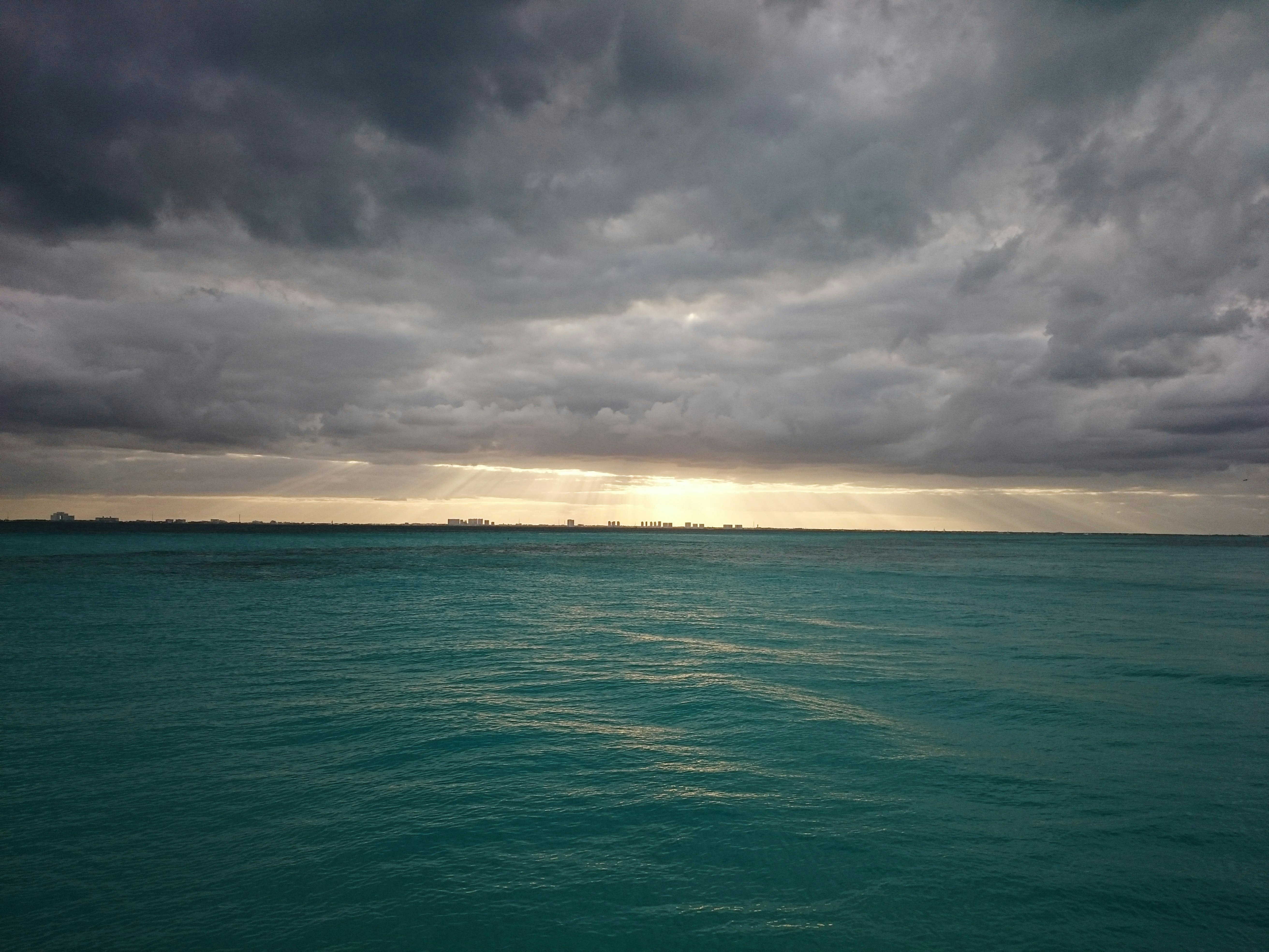 green body of water and white clouds